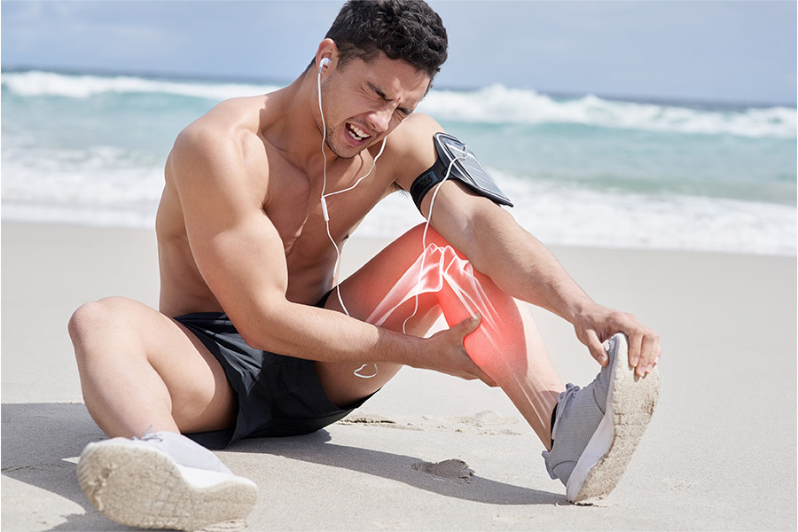 athlete-runner-man-sea-with-calf-pain-sports-injury-workout-training-fitness-exercise-miami-earphones-red-glow-person-with-accident-emergency-with-leg-muscle-beach