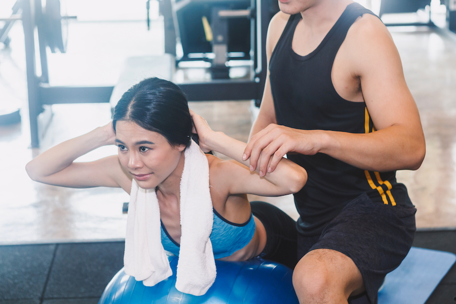 Handsome trainer and fitness woman at the gym.fitness and lifestyle concept