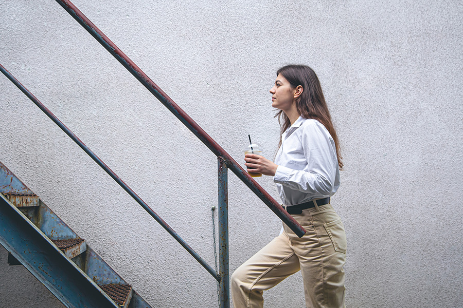 business-young-woman-near-stairs-with-cup-coffee